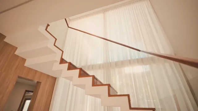 Wooden staircase and linen curtains in a bright house