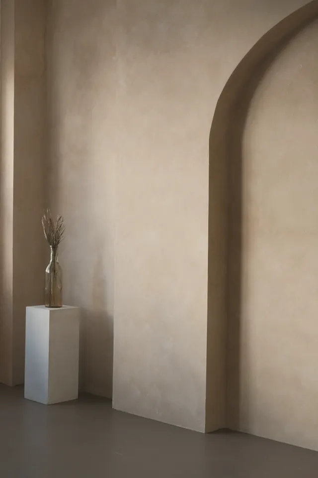 Arched opening in a lime-plastered wall