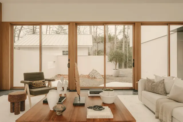 Furnished living room opening onto a garden through large windows
