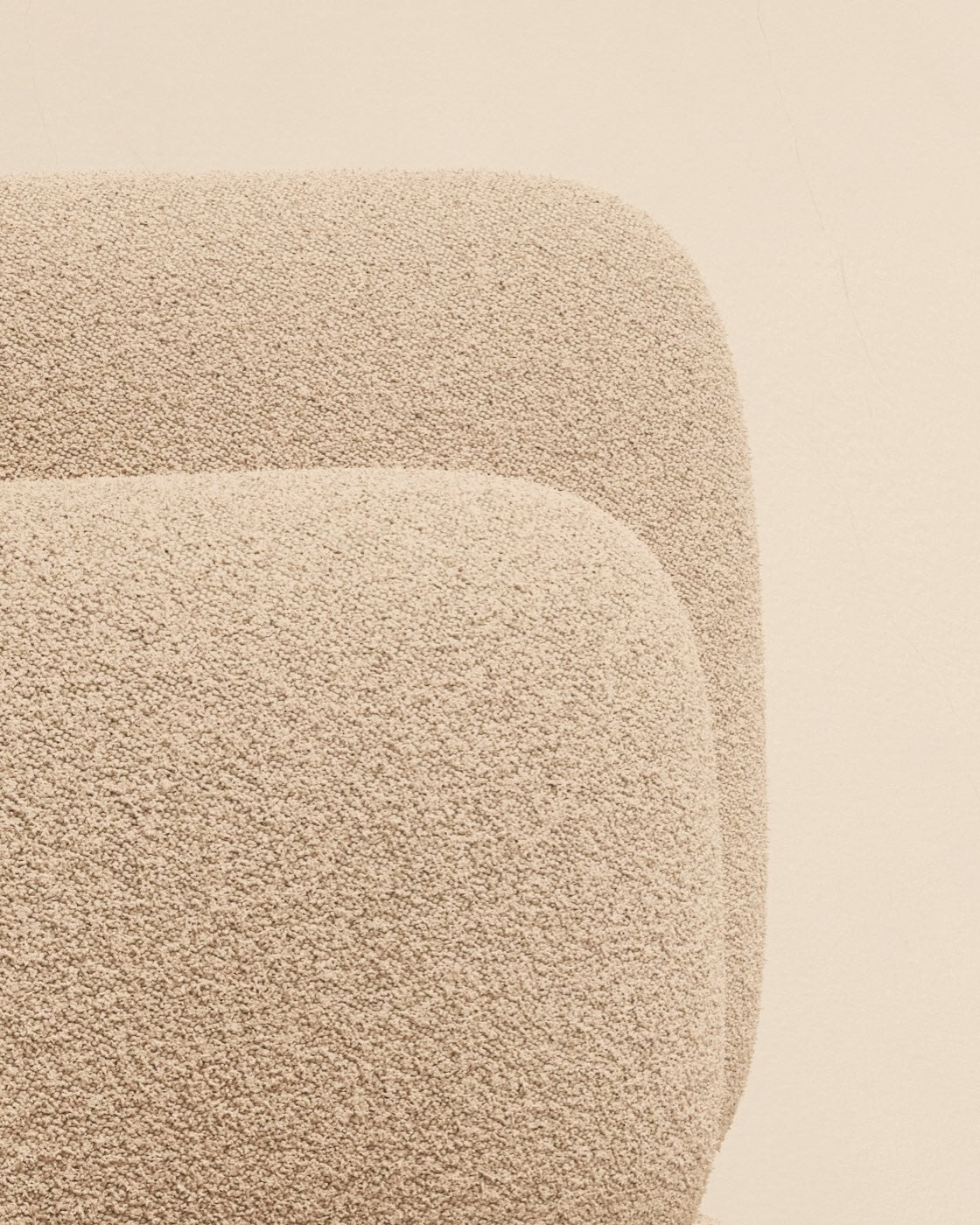 Gros plan d&rsquo;un tissu bouclette écru sur les courbes d&rsquo;un fauteuil