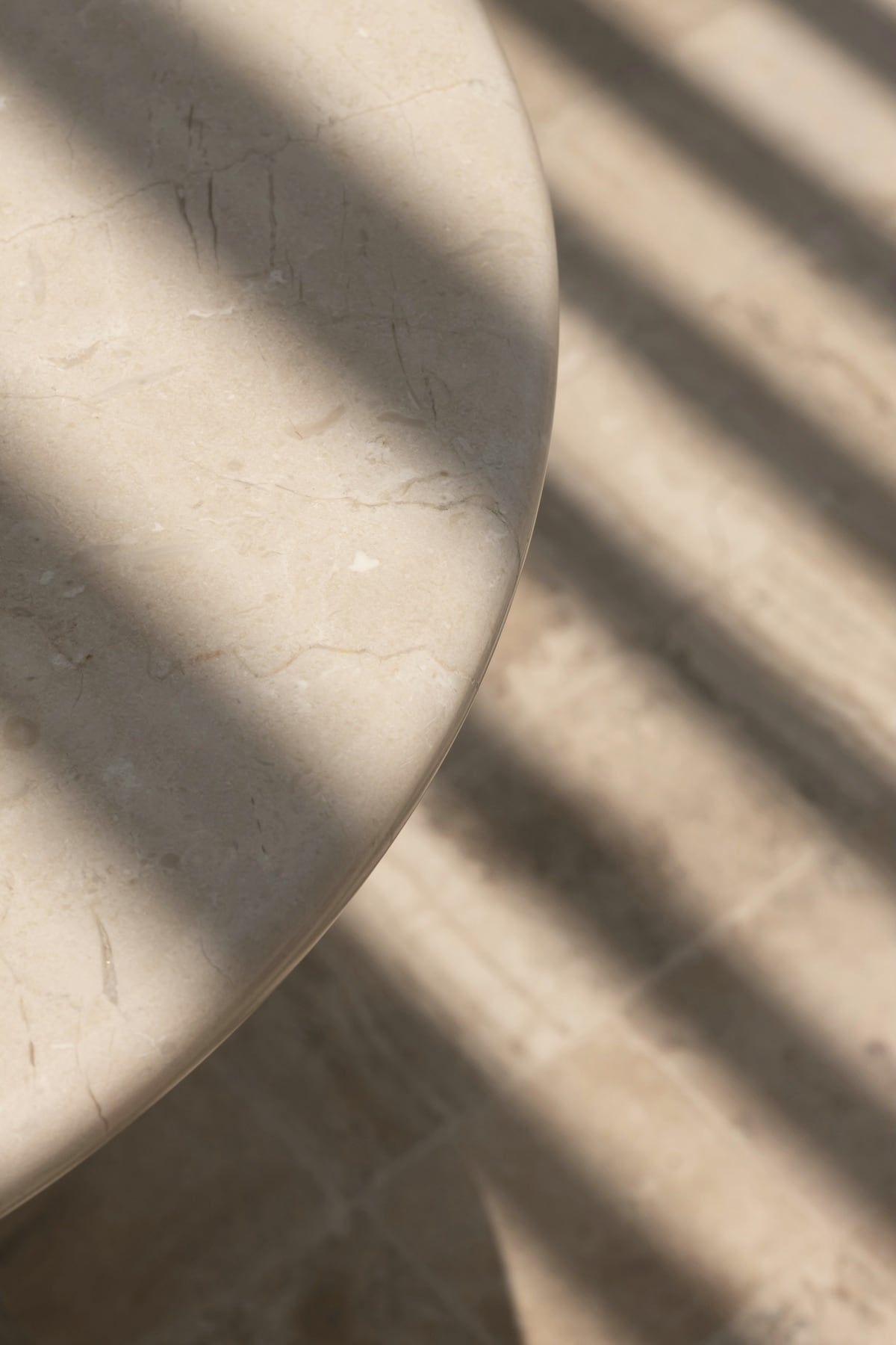 Détail du plateau en pierre beige traversé par des ombres rasantes