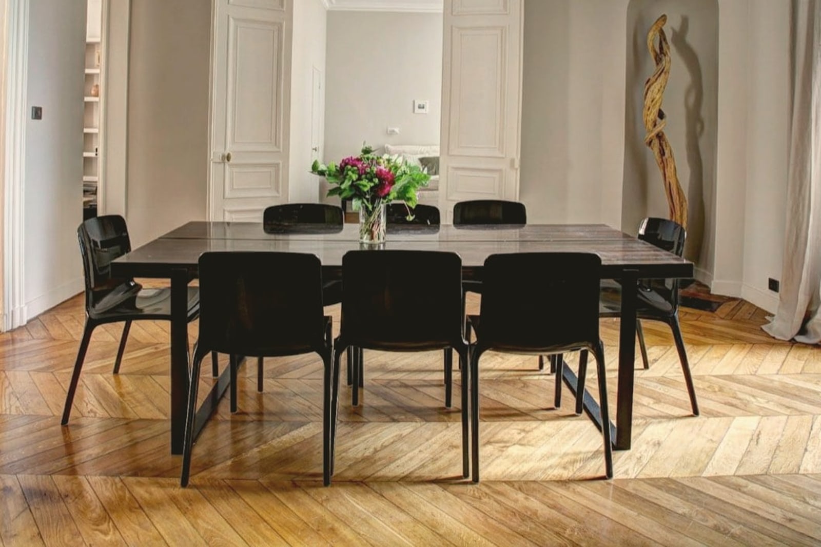 Appartement haussmannien : parquet en point de Hongrie, moulures, table et chaises noires
