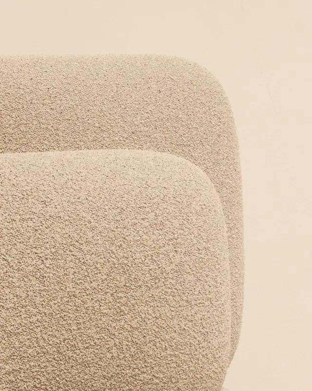Close-up of an ecru bouclé fabric on the curves of an armchair