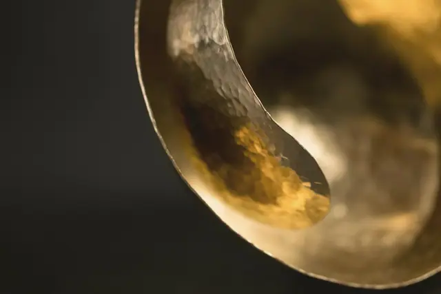 Hammered brass bowl on a black background, golden highlights